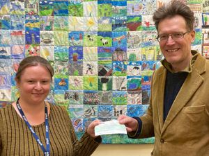 Ysgol Trefonnen’s Family Engagement Officer and well-bring officer Jen Craven receives £100 for the family fund from Llandrindod Wells North County Councillor Jake Berriman.