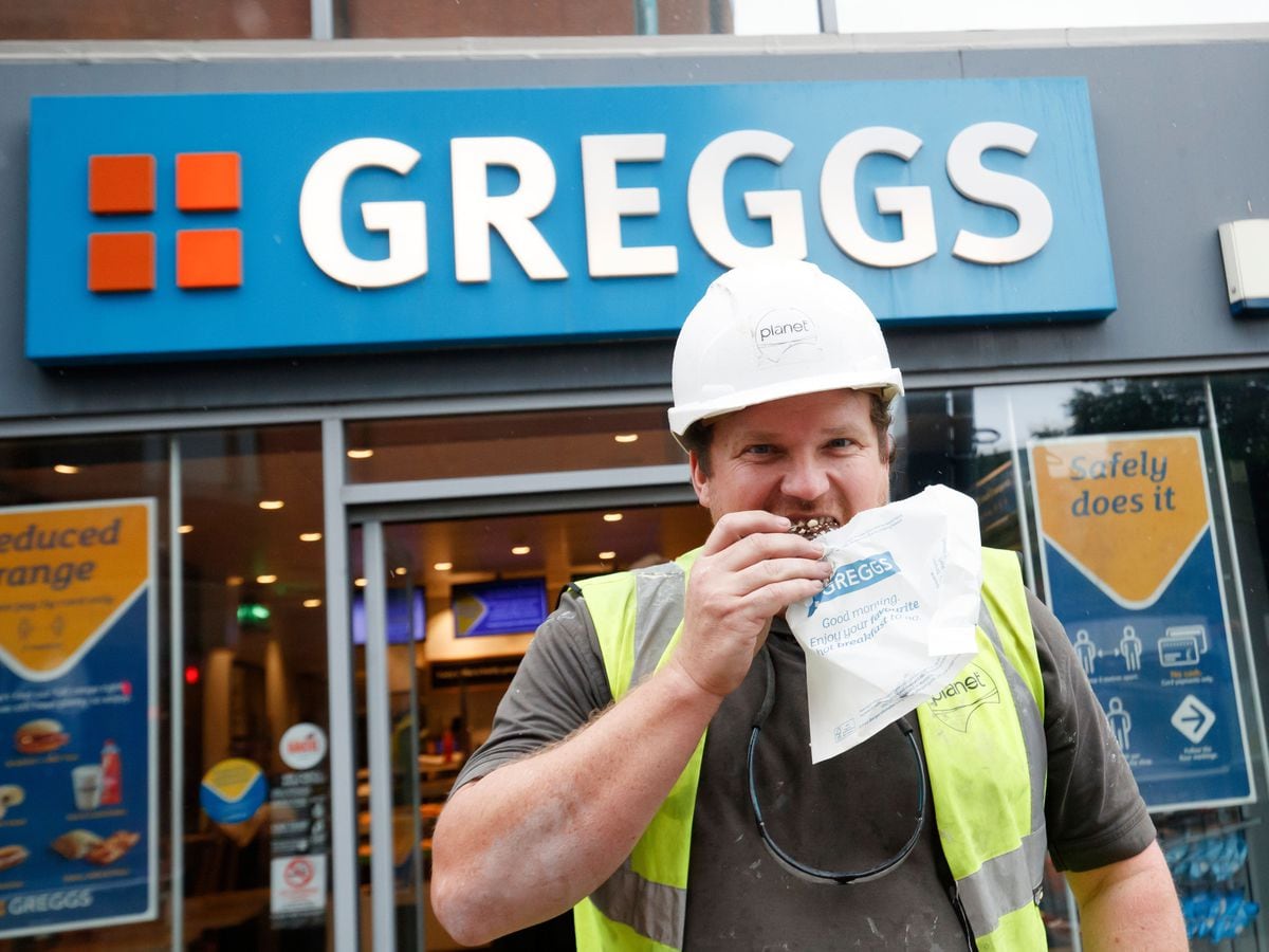 A customer outside a branch of Greggs