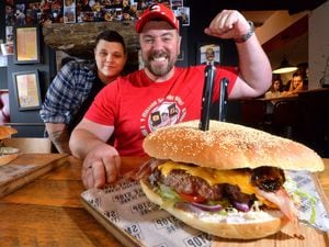  USA competitive eater Randy Santel  with the Houston Heart stopper burger. watched by Smokestop manager Harry Wedge