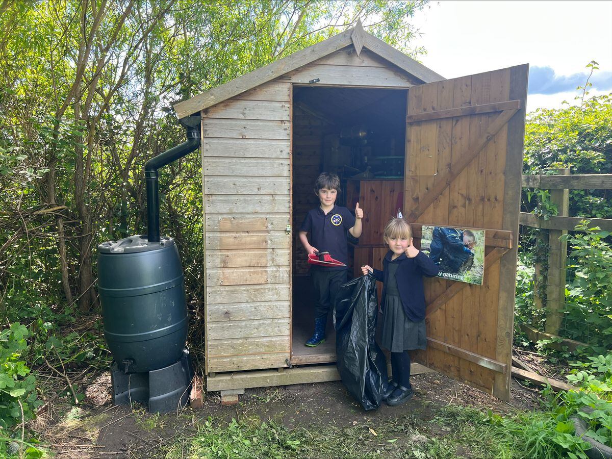 Dexter Evans and Zephie Littleford helping tidy up newly repaired shed in the forest school area at Morda CE Primary School