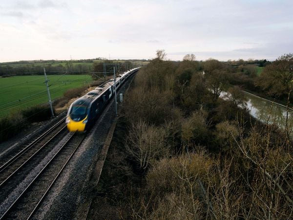 An Avanti West Coast train on a railway line near adjacent to the Grand Union Canal in Bugbrooke, Northamptonshire